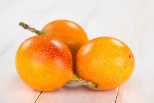 Sweet granadilla or grenadia (lat. Passiflora ligularis) fruit,  of which the seeds and the surrounding juicy pulp is eaten or is used to prepare juice (Selective Focus, Focus on the granadillas in the front)