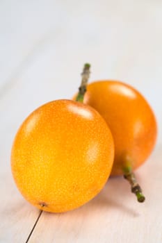 Sweet granadilla or grenadia (lat. Passiflora ligularis) fruit,  of which the seeds and the surrounding juicy pulp is eaten or is used to prepare juice (Selective Focus, Focus on the granadilla in the front)