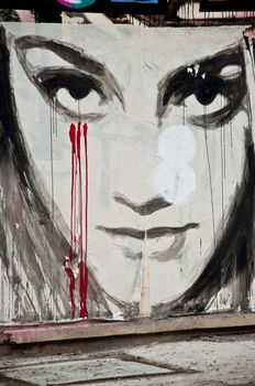 urban art  street in Paris- woman face with blood