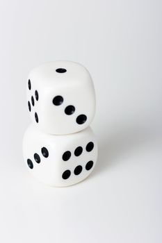 Two white dice with black dots on each other