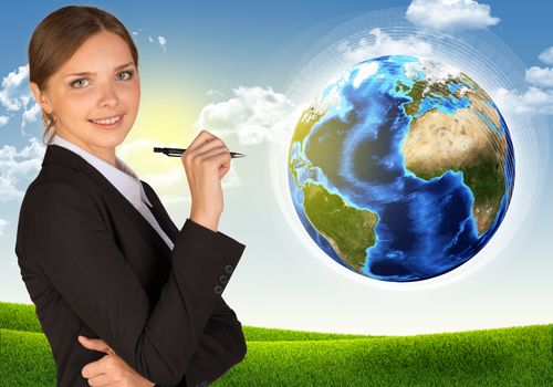 Businesswoman with pen looking at camera. Earth and landscape as backdrop. Elements of this image are furnished by NASA