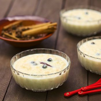 Three glass bowls of the Ecuadorian dessert called morocho (coarsely ground white corn) cooked with milk, sugar and spices (cinnamon and allspice), similarly to rice pudding (Selective Focus, Focus one third into the first morocho) 