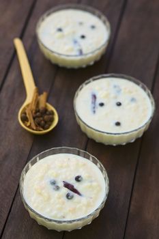 Three glass bowls of the Ecuadorian dessert called morocho (coarsely ground white corn) cooked with milk, sugar and spices (cinnamon and allspice), similarly to rice pudding (Selective Focus, Focus one third into the first morocho) 