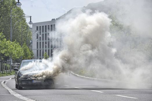 Burning and smoking car on the street