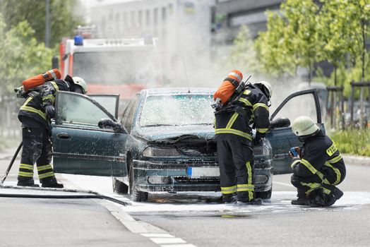 FREIBURG, GERMANY - JUNE 09: Firefighters are just putting out a burning and smoking car on the street on June 09, 2013 in Freiburg, Germany. No one was injured.