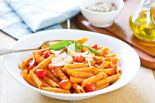 Penne with tomato sauce and shaving Parmesan on top