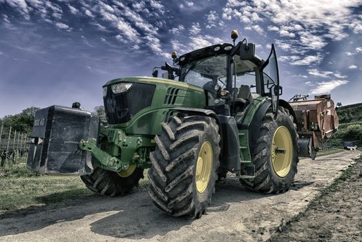 Modern Tractor in the Vineyard In Spring