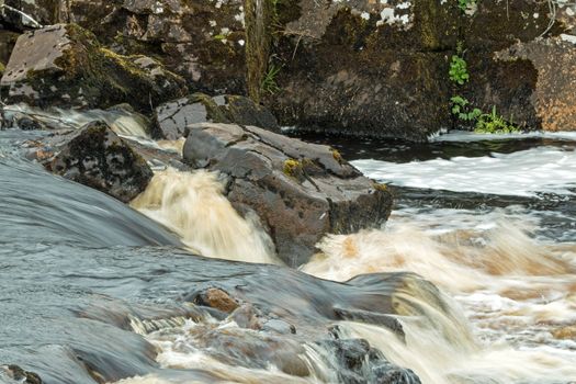 Fast-flowing peat-water river on The Isle of Skye, Scotland