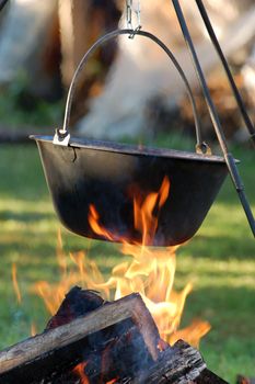 Typical Hungarian Gulyás (Soup) is jut cooking in Cauldron on Campfire