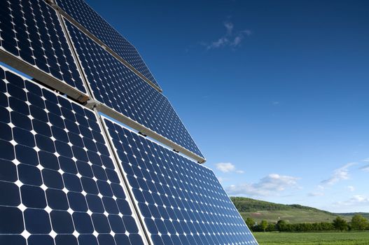 Solar Panel Against Blue Sky With Green Landscape