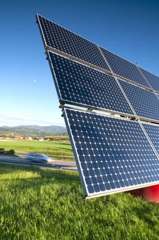 Solar Panel Against Blue Sky With Green Landscape And Highway