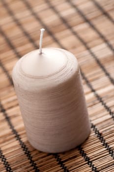 Candle on a brown background with shallow depth of field