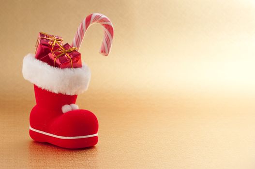 red christmas boot with gifts on gold background