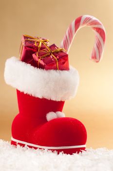 red christmas boot with gifts on gold background