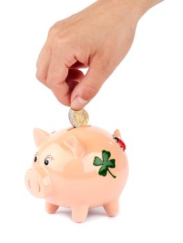 Woman putting coin in piggy bank isolated on white