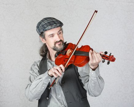 Single handsome Irish fiddler with beard playing music
