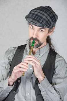 Handsome Irish folk musician playing tin whistle