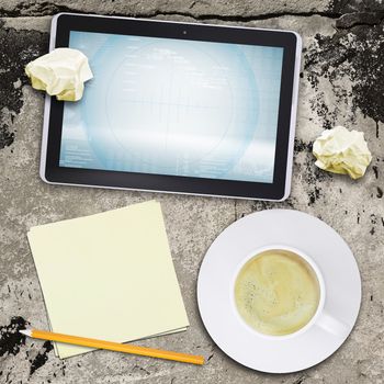 Tablet pc and coffee cup on old concrete surface. Computer technology concept