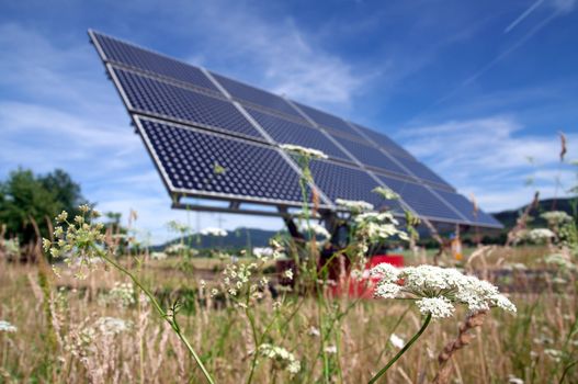 Solar panel with flower field and blue sky