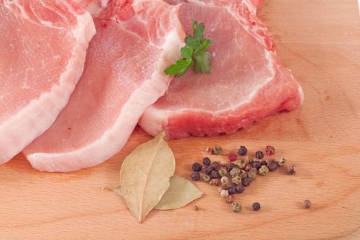 Pork chop and spices on a cutting board