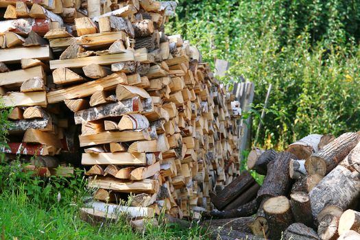 Dry chopped firewood logs in pile. Nature background.