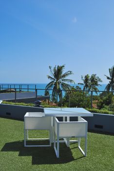 Terrace lounge with white rattan armchairs and seaview in a luxury resort .