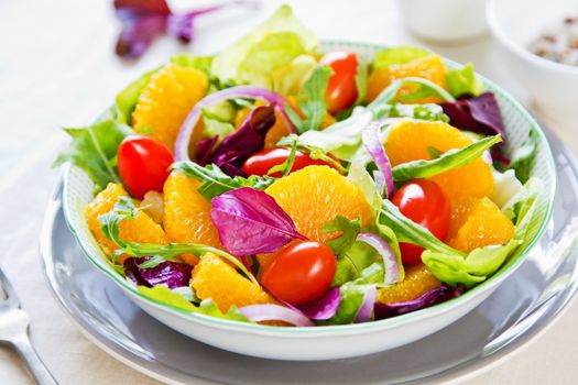 Orange with rocket and lettuce salad in a bowl,
