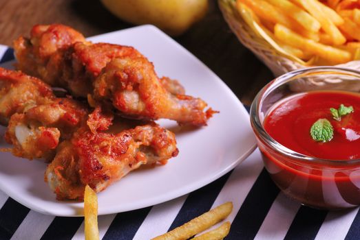 fried chicken wings with french fries and ketchup