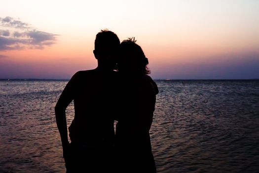 Couple Man and Woman holding hands in Love staying on Beach seaside with sunset scenery. People, Romantic, relationship and Friendship concept. 