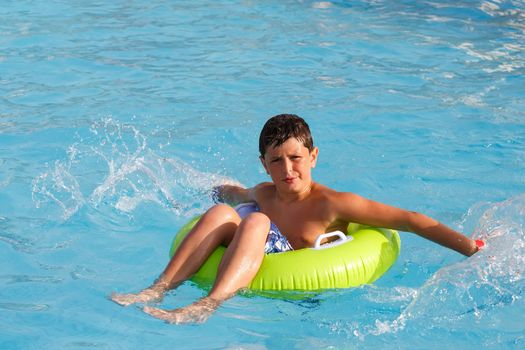 Boys, teenager swimsuit floating with swim ring in the pool float 