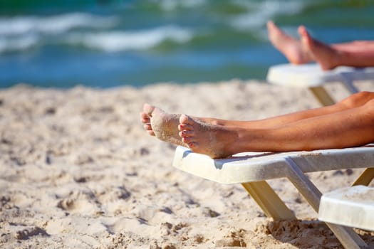 woman legs relaxing on the beach in sunny day, on tunisian beach.