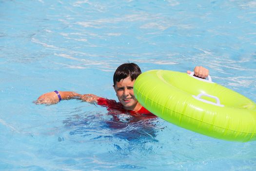 Boys, teenager swimsuit floating with swim ring in the pool float 