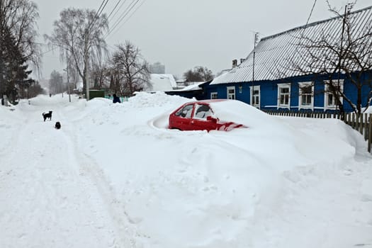Red car covered under snow after snow storm