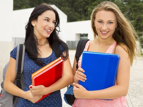 Two beautiful and happy teenage students smiling 