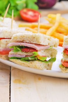 Club Sandwich with Cheese, Pickled Cucumber, Tomato and ham. Garnished with French Fries