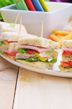 Club Sandwich with Cheese, Pickled Cucumber, Tomato and ham. Garnished with French Fries