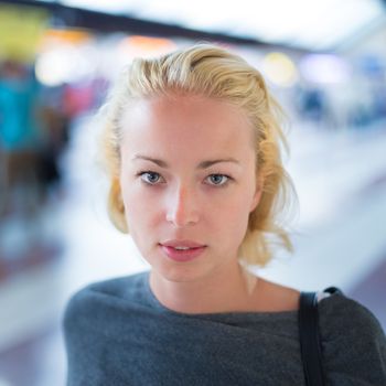 Young woman  waiting on the platform of a railway station for their train. to arrive.