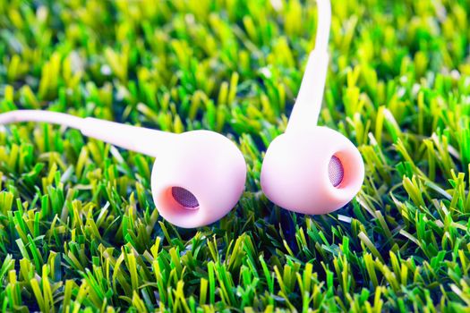 White earphones in the grass, close up