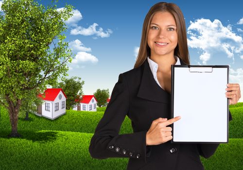 Businesswoman holding paper holder. Blue sky, green grass and town as backdrop