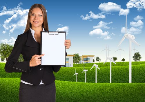 Businesswoman holding paper holder. Blue sky, green grass and town as backdrop