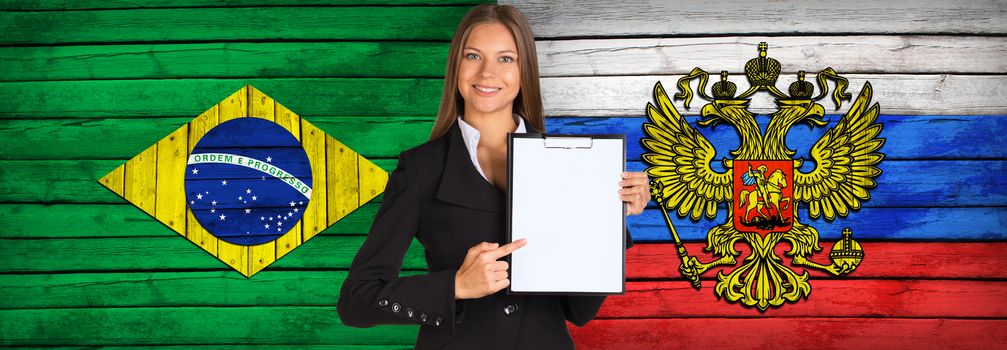 Businesswoman holding paper holder. Brazil and Russian flags as backdrop