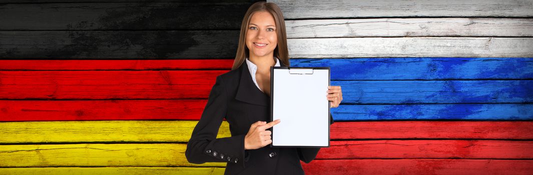 Businesswoman holding paper holder. Germany and Russian flags as backdrop