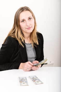 Portrait of young woman counting money