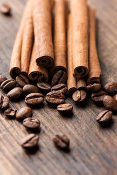 Coffee and cinnamon sticks on grunge wooden background