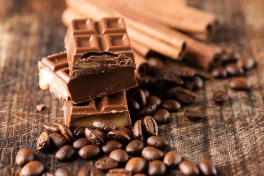 Coffee beans with chocolate candy bar on wooden table