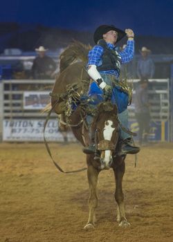 LOGANDALE , NEVADA - APRIL 10 : Cowboy Participating in a Bucking Horse Competition at the Clark County Fair and Rodeo a Professional Rodeo held in Logandale Nevada , USA on April 10 2014 