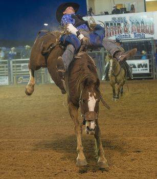 LOGANDALE , NEVADA - APRIL 10 : Cowboy Participating in a Bucking Horse Competition at the Clark County Fair and Rodeo a Professional Rodeo held in Logandale Nevada , USA on April 10 2014 