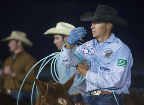 LOGANDALE , NEVADA - APRIL 10 : Cowboy Participating in a Calf roping Competition at the Clark County Fair and Rodeo a Professional Rodeo held in Logandale Nevada , USA on April 10 2014