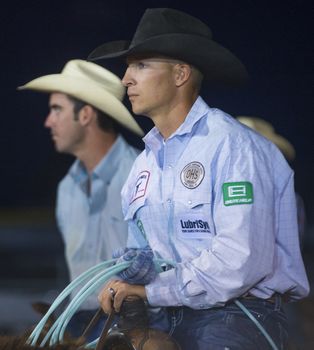 LOGANDALE , NEVADA - APRIL 10 : Cowboy Participating in a Calf roping Competition at the Clark County Fair and Rodeo a Professional Rodeo held in Logandale Nevada , USA on April 10 2014