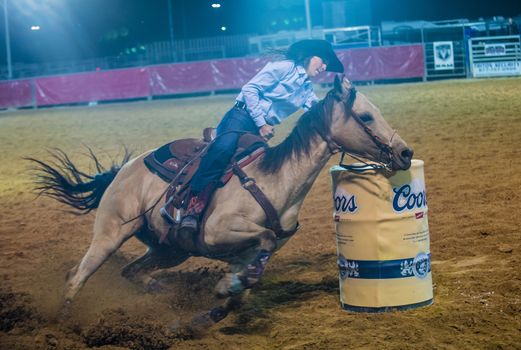 LOGANDALE , NEVADA - APRIL 10 : Cowgirl Participating in a Barrel racing competition in the Clark County Fair and Rodeo a Professional Rodeo held in Logandale Nevada , USA on April 10 2014